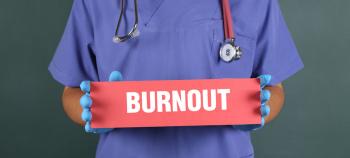 Medical professional holding a sign that reads, "BURNOUT."